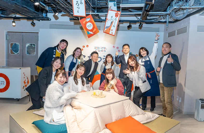 こたつを囲むメンバーの集合写真