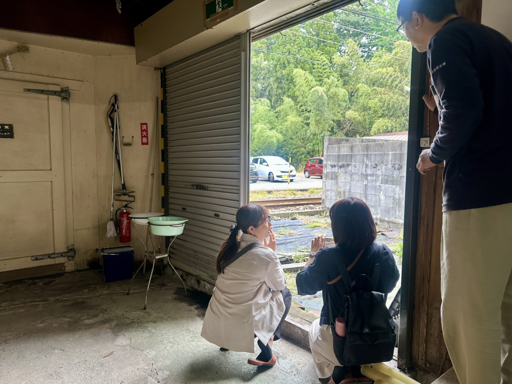 田辺酒造の室内から線路を覗く酒小町メンバー